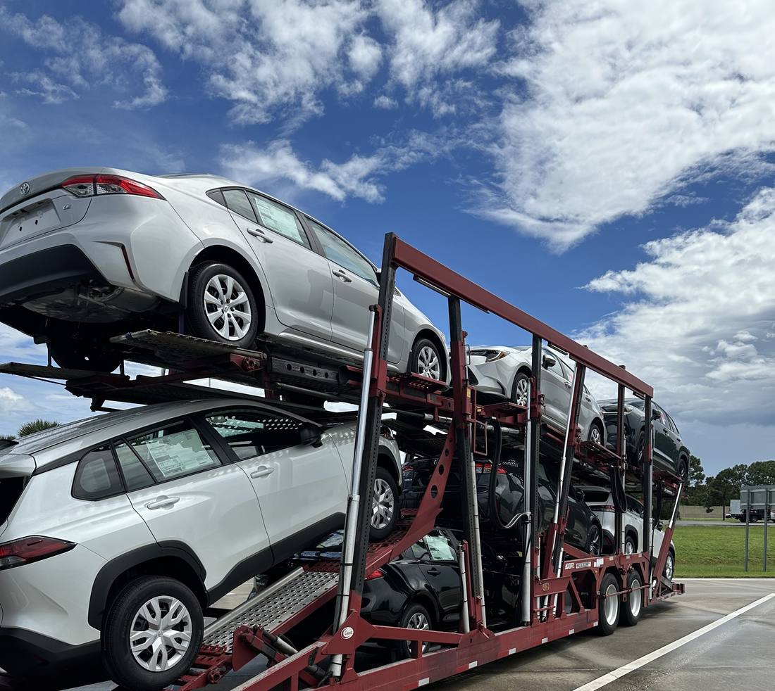 A multi-car hauler loaded with sedans and an SUV, ready for transport